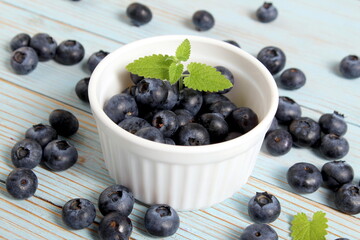 There is a bowl of ripe blueberries on the table.	