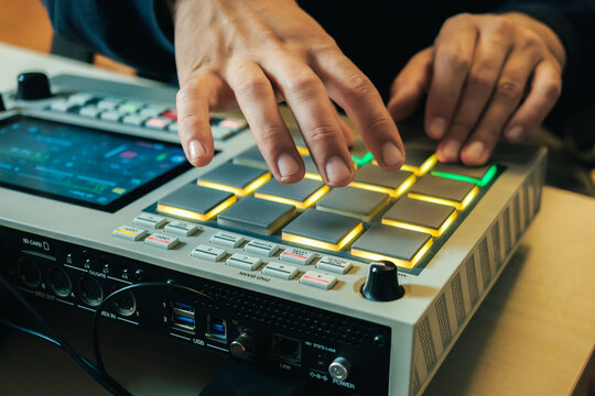 The hands of an artist creating music with his drum machine MPC LIVE II