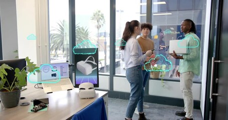 Product designer tapping tablet while cloud icons forming around teammates showing VR team review - Powered by Adobe