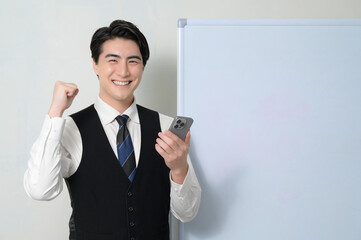 スマホを持って喜ぶ日本人男性