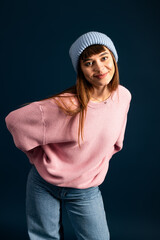 Beautiful young woman posing warmly in stylish autumn attire against a dark background