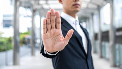 Businessman in Suit Showing Stop Hand Gesture to Signal Prohibition or Warning