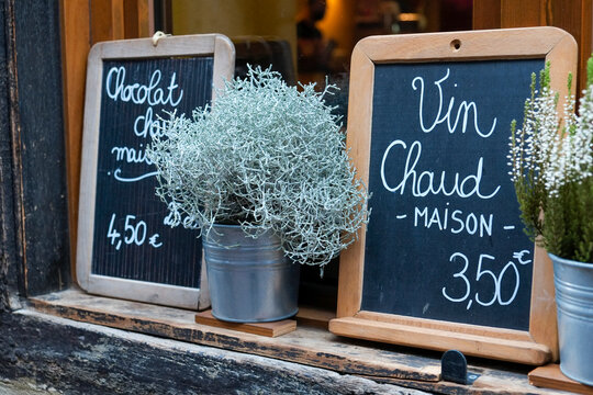Colmar, France. Europe. Cafe selling hot wine and hot chocolate as written in French on the black board. 