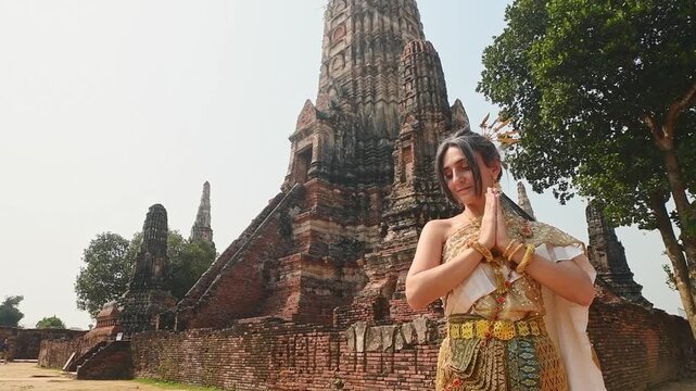Thailand, Ayutthaya - march 15th, 2023: Woman in traditional Thai dress pose sightseeing visit ancient Buddha statue.Ayutthaya historical park. UNESCO World Heritage Site