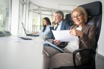 No one can whistle a symphony. It takes a whole orchestra to play it. Business meeting. Businesspeople laughing while working at an office table. three business people talking about contract.	