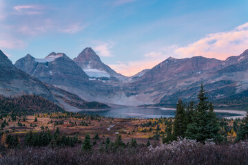 Golden sunrise light hitting Mount Assiniboine with Lake Magog below, showcasing breathtaking alpine beauty and a pristine wilderness landscape at dawn