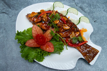 Whole Fried Fish with Spicy Chili Garlic Sauce, Mushrooms, and Elegant Tomato Garnish in tray dish top view of japanese food