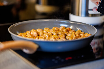 Delicious chicken bites cooking in a pan on the hob, ready for dinner