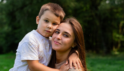 Fototapeta premium Cute preschooler boy hug cuddle with smiling young mother. Intimate moment between mom and son. Kissing show love. Embrace happy millennial mom