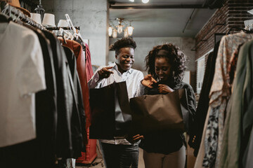 Happy Couple Shopping In Boutique Store, Smiling At Each Other While Carrying Bags