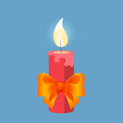 Burning red candle with bright yellow bow festive Christmas decoration isolated on blue background