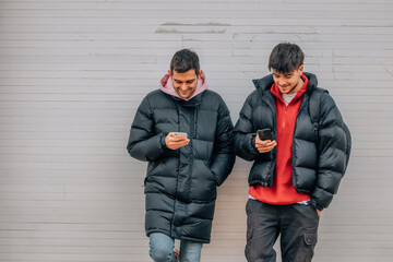 young people on the street with mobile phone in winter with warm clothes