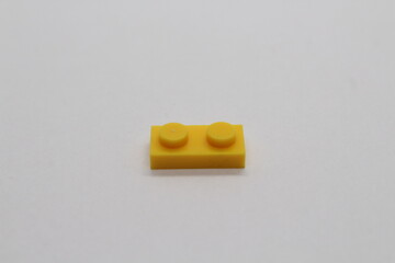 Obraz premium Yellow Lego brick piece isolated on a white background 