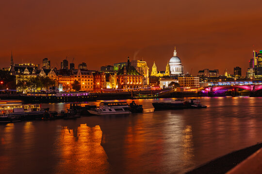 Night view of St Paul’s Cathedral and illuminated city buildings reflected in River Thames in London
