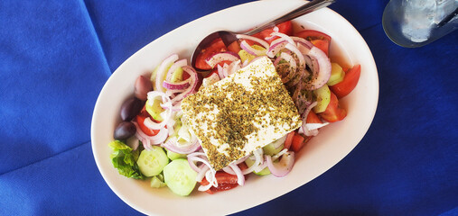A unique presentation of Greek salad. A light vegetable salad with feta cheese and olives. A delicious snack. Vitamins and minerals, diet, and healthy eating.