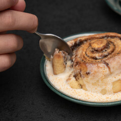 Chocolate dessert on plate served with hand holding fork.