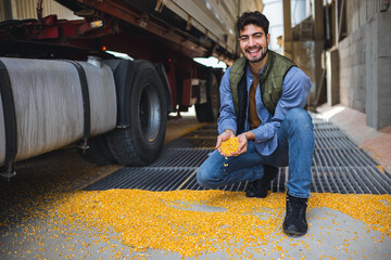 Young worker holding corn kernels during unloading