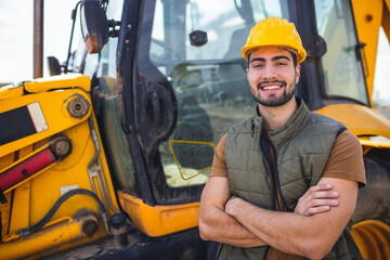 Young excavator operator standing in front of excavator