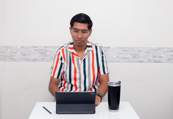 Joven viendo  su tablet de estudio y cafe