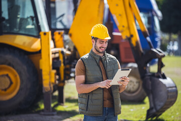 Excavator operator with tablet at construction site