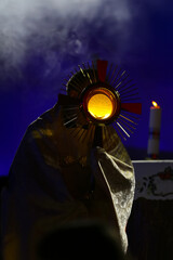 Priest holding the Blessed Sacrament of the Eucharist,
