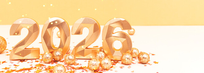 2026 - numbers and confetti in front of beige and golden background. New Year celebration concept with place for text.