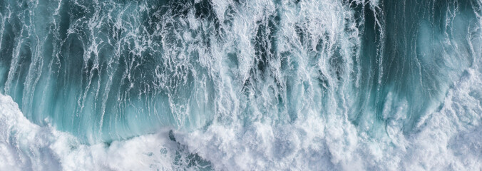 Drone view of rough ocean surf and waves hitting the rocky shoreline