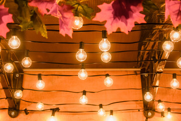 Small incandescent lamps burning brightly under a cafe canopy