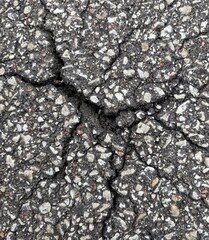 Cracked asphalt texture with visible stones and rough surface