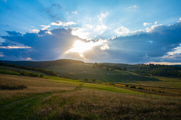 Golden Sunset Over Rolling Hills and Fields