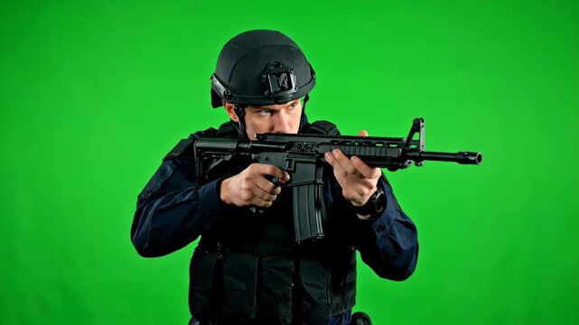 Soldier Aiming Rifle on Green Screen - A soldier in full tactical gear, including a helmet and vest, aims a rifle directly at the viewer.