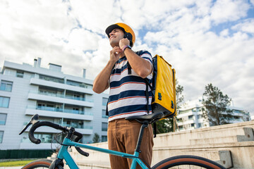 Hispanic male delivery man adjusting bicycle helmet