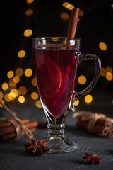 Glass of Mulled Wine with Citrus and Cinnamon on Festive Dark Background