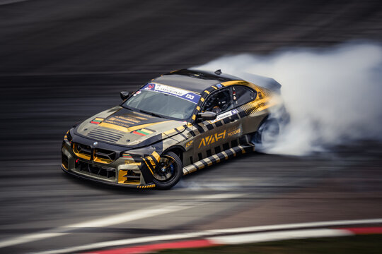 Latvia, Riga 03-05.10.2025. FIA Drifting cup,  a BMW M4 drifting on a track with smoke billowing out of it, creating a blurred background