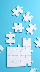 White jigsaw puzzle pieces scattered on a light-blue background