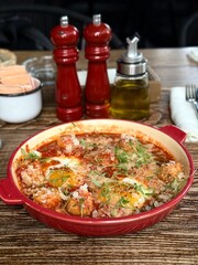 Rustic Shakshuka with Poached Eggs and Tomato Sauce in Red Pan