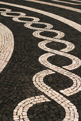 Portugal, Azores Islands, Ponta Delgada capital of Sao Miguel Island. Typical old Portuguese black and white mosaic cobblestone paving.  Volcanic basalt stone and limestone found on the island.