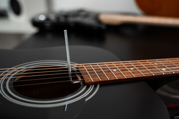 Naklejka premium Adjusting a guitar truss rod. Guitarist adjusting the truss rod inside the acoustic guitar. Fine-tuning an acoustic guitar truss rod with precision using an Allen key.