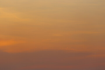 A Tranquil Sunset Sky Displaying Soft Hues of Orange and Yellow Over a Gentle Horizon, Evoking a...