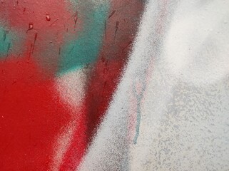 Colorful Abstract Wall Pattern. A vivid spray paint pattern on a wall features bold red and teal colors blending together. Slight textures and drips add depth.