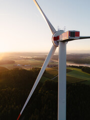 Wind Turbine at Sunrise Over Forest and Farmland