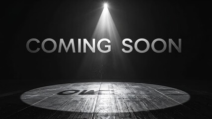 Coming soon text illuminated by spotlight on stage with wood floor