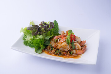 Shrimp Salad, Thai food, fresh red shrimp with red-brown dressing, lemongrass, mint leaves, salad greens as a side dish, placed on a white plate, white background. © bae