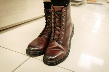 Classic brown leather combat boots with black laces and a rugged sole, combining durability with timeless style for everyday or urban wear.