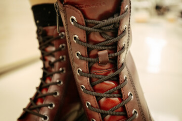 Classic brown leather combat boots with black laces and a rugged sole, combining durability with...