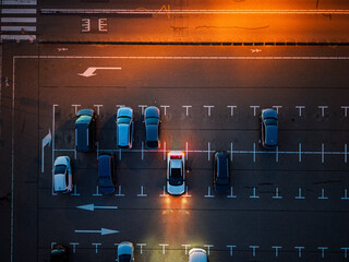 Katwijk aan Zee, South Holland, Netherlands - 09.06.2025: Aerial nighttime view of empty parking lot warm orange streetlights illuminate marked lanes and scattered cars, highlighting symmetry