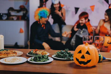Joyful office Halloween party with coworkers in costumes, celebrating with drinks and laughter, fostering teamwork and festive spirit