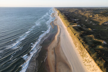Aerial View of Serene Coastal Beach with Ocean Waves and Grassy Terrain