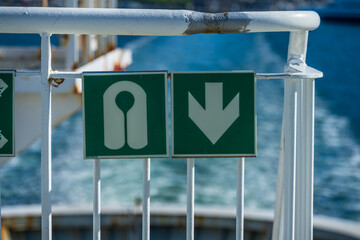 Lifesaving equipment signs mounted on ferry rail.