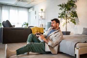 Man playing video game at home with controller enjoying leisure
